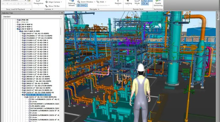 3D model of an industrial plant with colorful pipes and equipment; a worker in a hard hat stands in the foreground, viewing the scene.